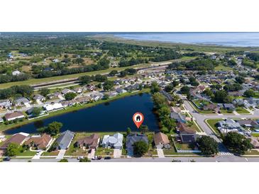 Stunning aerial view of a lakeside home nestled in a tranquil community with lush green surroundings and serene water views at 3928 Blackberry Cir, St Cloud, FL 34769