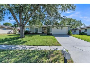 Charming single-story home featuring a well-manicured lawn and a two-car garage, set under a large tree at 503 Gumwood Ct, Altamonte Springs, FL 32714