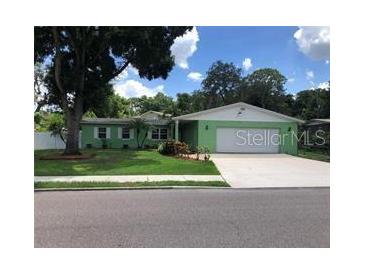 Charming green ranch-style home with a well-manicured lawn and a two-car garage at 5178 Mustang Way, Orlando, FL 32810