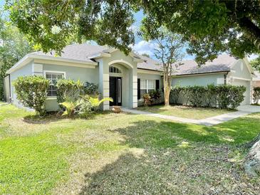 Charming single-story home with a manicured front yard and beautiful landscaping at 671 Carey Way, Orlando, FL 32825