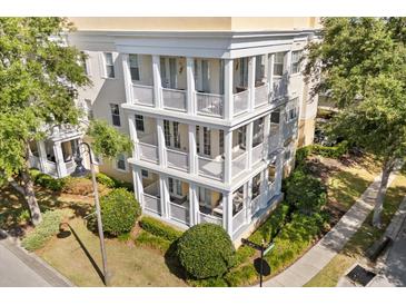 Beautiful condo building with a charming design, featuring multiple balconies and well-maintained landscaping at 7505 Mourning Dove Cir # 201, Reunion, FL 34747
