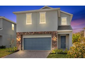 Charming two-story home with a blue garage door, brick accents, and a well-maintained front lawn at 1251 Ash Tree Cv, Casselberry, FL 32707