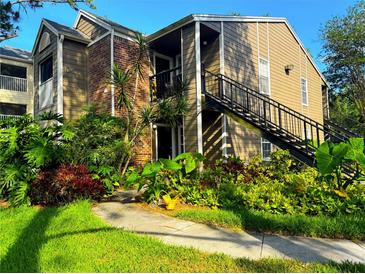 Inviting two-story home with lush landscaping, brick accents, and an exterior staircase at 2213 Metropolitan Way # 1318, Orlando, FL 32839