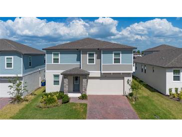 Lovely two-story home with a brick driveway, well-kept lawn, and a covered entrance at 2310 Raven Ridge Rd, Minneola, FL 34715