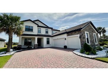 Elegant two-story home featuring a brick driveway, attached two-car garage and beautifully landscaped front yard at 2920 Agostino Ter, Kissimmee, FL 34746