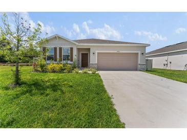 Charming single-story home featuring a manicured lawn, stone accents, and a two-car garage at 33263 Rembrandt Ln, Sorrento, FL 32776
