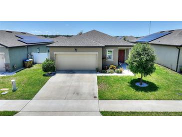 Charming single-story home featuring a well-maintained lawn, two-car garage, and solar panels for energy efficiency at 5816 Beefmaster Rd, St Cloud, FL 34771