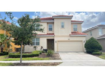 Charming two-story home featuring a red tile roof, neutral stucco and a well-manicured front yard at 6041 Broad Oak Dr, Davenport, FL 33837