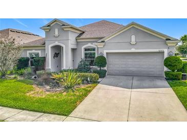 Charming single-story home featuring a well-manicured lawn and attached two-car garage at 12313 Prairie Plantation Way, Orlando, FL 32824