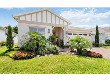 Well-manicured front yard with palm trees, decorative plants, and charming curb appeal at 3378 Sagebrush St, Harmony, FL 34773