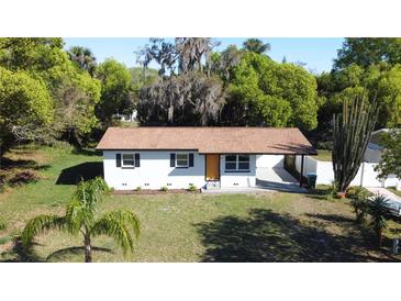 Charming single-story home featuring a manicured lawn and lush landscaping with a private drive at 453 E Jessup Ave, Longwood, FL 32750