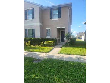 Inviting two-story home featuring neatly trimmed hedges and a well-manicured front lawn at 4819 Apple Blossom Ln, St Cloud, FL 34771