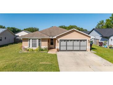 Charming single-story home featuring a well-maintained lawn, neutral paint, and attached two car garage at 1543 Reade Cir, St Cloud, FL 34772
