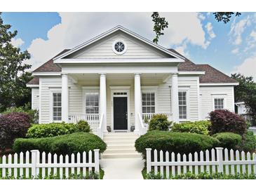 Charming home featuring a classic white picket fence, complemented by lush greenery and a welcoming front porch at 204 Celebration Blvd, Celebration, FL 34747