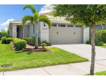 Charming single-Gathering home featuring a manicured lawn, mature landscaping, and a two-car garage with modern accents at 3428 Sagebrush St, St Cloud, FL 34773