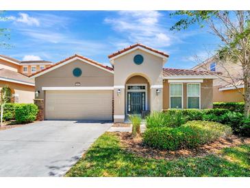 Charming single-story home with a well-manicured lawn, attached garage, and a decorative front entrance at 4416 Acorn Ct, Davenport, FL 33837