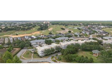 Beautiful aerial view of the condo community nestled among lush landscaping and a well-manicured golf course at 7509 Mourning Dove Cir # 303, Reunion, FL 34747