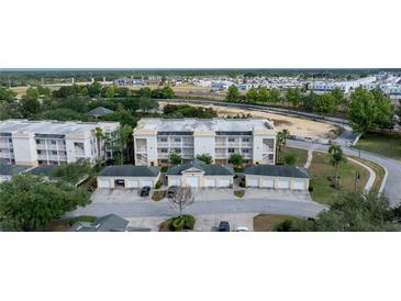 An aerial view of the condo buildings featuring attached garages and beautiful landscaping at 7509 Mourning Dove Cir # 303, Reunion, FL 34747