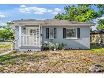 Charming exterior showcasing the white porch, complemented by black shutters and gray siding at 1024 Cohassett Ave, Lake Wales, FL 33853