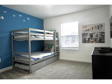 Charming bedroom featuring a bunk bed, Star Wars themed decor, and a bright blue accent wall at 1160 Kingsbarn St, Davenport, FL 33896