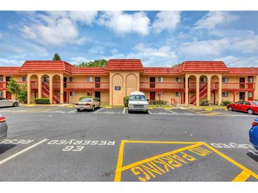 Condo complex exterior with well-defined parking spaces and pedestrian access to each unit at 2864 N Powers Dr # 150, Orlando, FL 32818