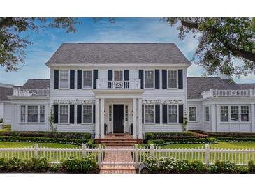 Charming two-story white home with black shutters and manicured landscaping offers timeless curb appeal at 423 Arbor Cir, Celebration, FL 34747