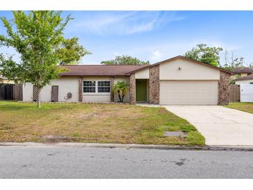 Charming single-story home with a well-manicured lawn, stone accents, and a two-car garage at 4412 Mesa Verde Dr, St Cloud, FL 34769