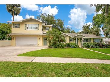 Charming two-story home with well-maintained lawn and lush landscaping at 606 N Mcdonald St, Mount Dora, FL 32757