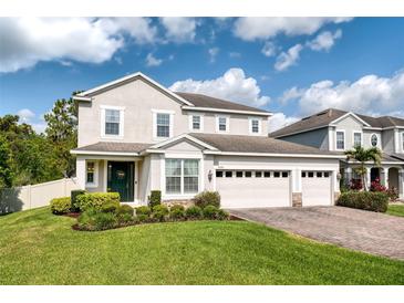 Beautiful two-story home with a three car garage, brick paver driveway and lush landscaping at 6080 Fender Ct, Orlando, FL 32837