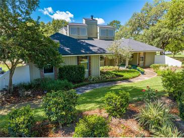 Charming home featuring lush landscaping, a winding walkway, and unique architectural details at 6464 Timberwind Pl, Orlando, FL 32818