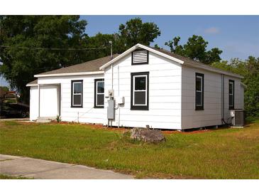 Exterior view of a white house with a green lawn and black trimmed windows at 709 28Th Nw St, Winter Haven, FL 33881