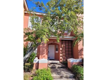 Charming two-story townhouse featuring a walkway, decorative shutters, and lush landscaping at 153 Pompano Beach Dr Dr, Kissimmee, FL 34746