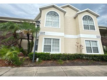 Beige two-story condo building featuring arched windows, manicured landscaping, and prominent address numbers at 2330 Prime Cir # A, Kissimmee, FL 34746