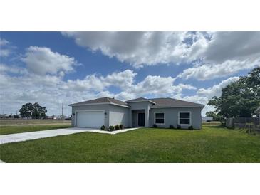 Charming single-story home featuring a well-manicured lawn, a two-car garage, and a covered entryway at 2427 Continental Blvd, Orlando, FL 32808