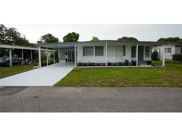 Charming single-story home with covered parking, landscaped yard, and freshly painted driveway at 2618 Brookside Cir, Mount Dora, FL 32757