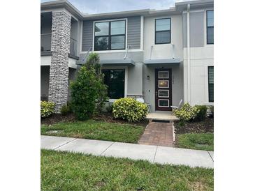 Stylish townhome with modern design, manicured landscaping, and inviting front entrance at 2702 Giardino Loop, Kissimmee, FL 34741