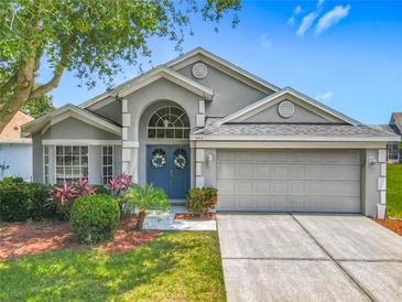 Charming single-story home featuring a well-manicured lawn and double front doors with decorative wreaths at 4413 Chalfont Dr, Orlando, FL 32837