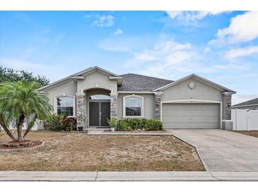 Charming single-story home with stone accents, neutral stucco, and a well-manicured lawn at 491 Majestic Gardens Blvd, Winter Haven, FL 33880