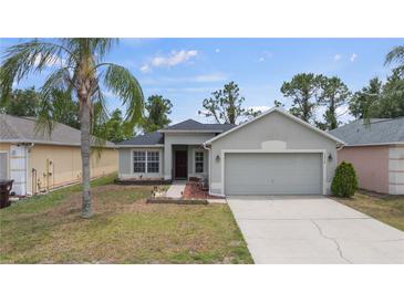 Charming single-story home featuring a well-maintained front yard, attached two-car garage, and neutral colored paint at 5210 Silver Thistle Ln, St Cloud, FL 34772