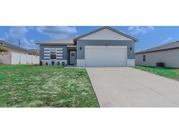 Charming single-Gathering home featuring a well-manicured lawn and a two-car garage with a classic white door at 109 Lily Ln, Poinciana, FL 34759