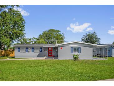 Charming single-story home with a red front door, blue shutters, and a well-maintained lawn at 6824 Chaucer Ln, Orlando, FL 32809