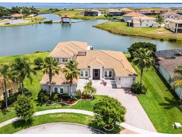 Stunning waterfront home with a well-manicured lawn, tile roof, and lush landscaping, perfect for serene living at 1110 Terralago Way, Kissimmee, FL 34746