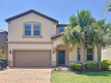 Beautiful two-story home with a red brick driveway, a 2-car garage, and palm trees in the front yard at 1614 Lima Ave, Kissimmee, FL 34747
