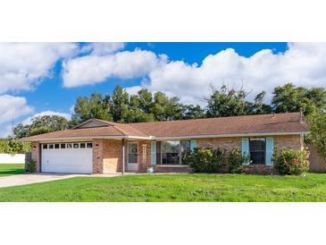 Charming single-story home with a brick facade, well-manicured lawn, and vibrant blue shutters at 1730 Carolyn Ct, St Cloud, FL 34769