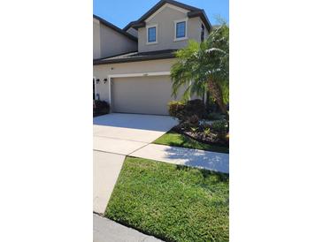 Charming townhome featuring a well-manicured lawn, two car garage and lovely landscaping at 2289 Seven Oaks Dr, St Cloud, FL 34772