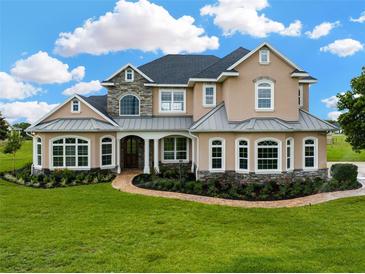 Stunning two-story home featuring stone accents, a manicured lawn and meticulous landscaping in a suburban neighborhood at 2350 Bradbury Rd, Haines City, FL 33844