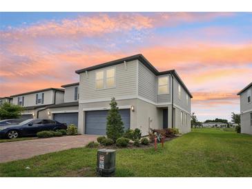 Charming two-story townhome featuring an attached garage, manicured lawn, and a welcoming entrance at 2462 Sweet Viburnum Way, Ocoee, FL 34761