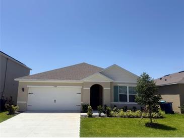 Charming single-story home with a well-maintained lawn and attached two-car garage at 2569 Trinidad Rd, Haines City, FL 33844