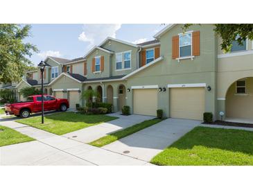 Inviting townhouse exterior with a two-car garage and well-maintained landscaping and beautiful shutters at 3181 Tocoa Cir, Kissimmee, FL 34746