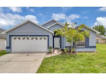Charming single-story home with a well-manicured lawn, a two-car garage, and appealing curb appeal at 664 Eagle Pointe S, Kissimmee, FL 34746